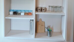 Une étagère blanche contenant divers ustensiles de cuisine.
