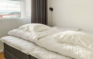 A neatly made bed with white bedding in a room with a window and a view of a bridge. - Lovely apartment in Myggenäs with WiFi (Myggenäs)