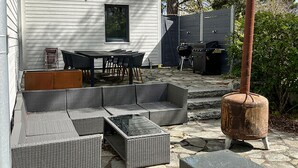 Una terrazza con un divano componibile, un tavolo e sedie.