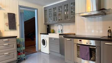 A modern kitchen with stainless steel appliances, a built-in oven, and a washing machine.
