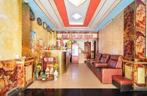 A hotel lobby with a reception desk, seating area, and decorative elements.