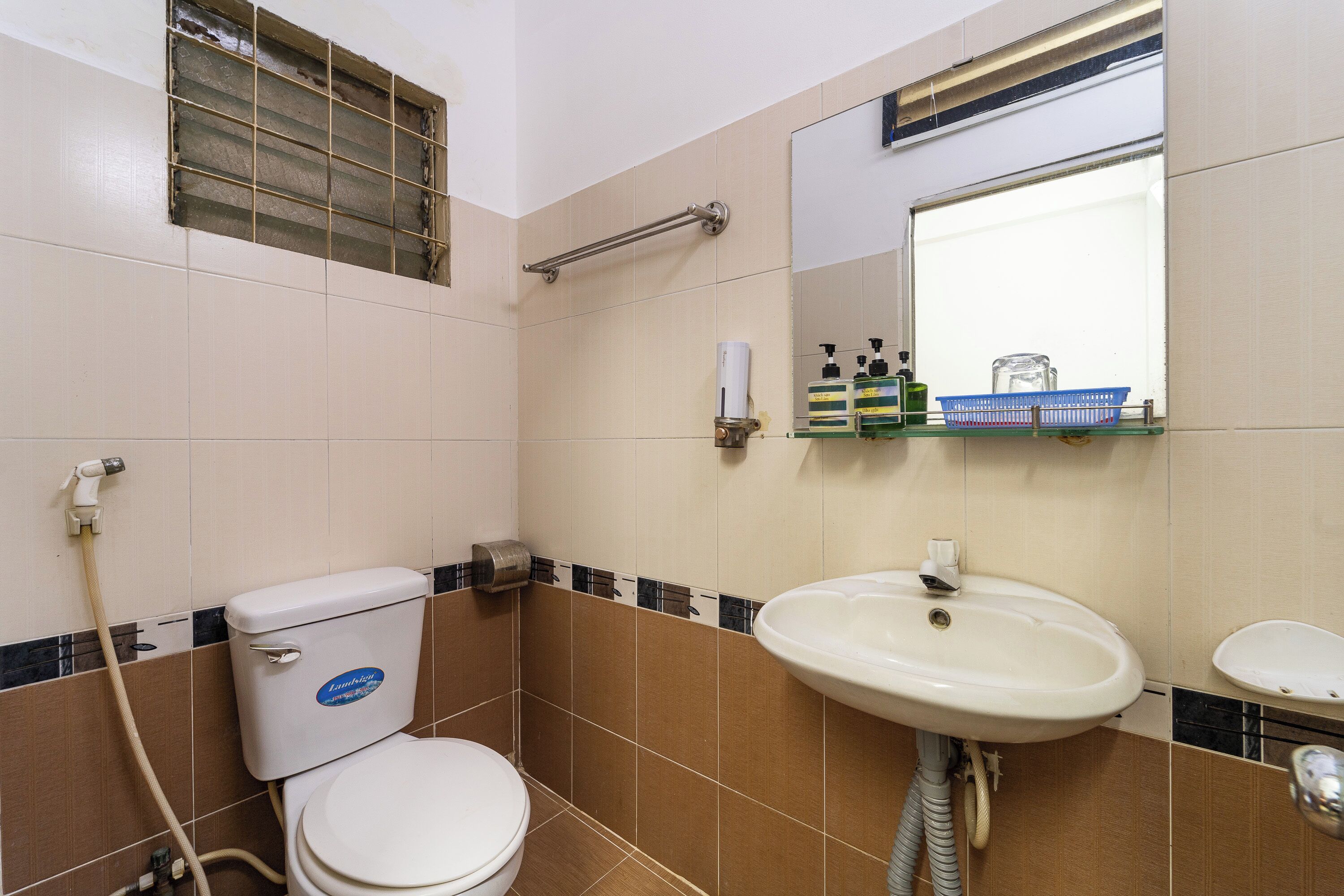 A bathroom with a toilet, sink, and mirror.