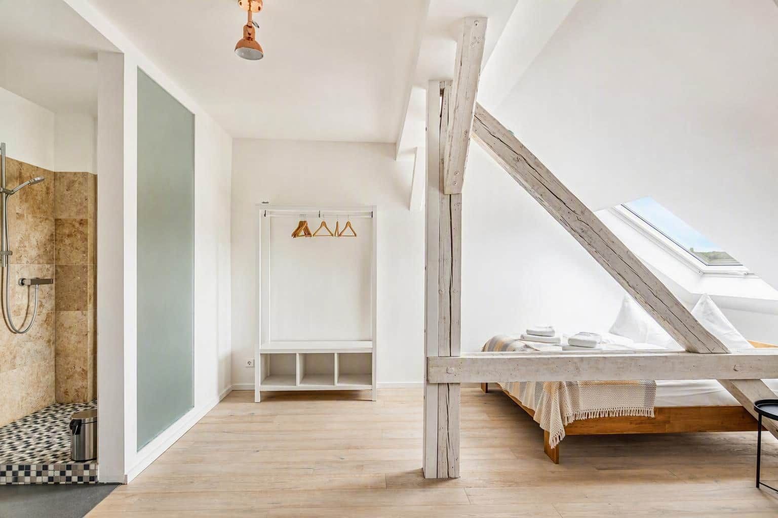 Un dormitorio moderno con tragaluces, estructura de cama de madera y banco empotrado.