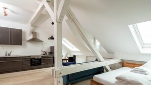 A compact, modern apartment with a loft-style bedroom, kitchenette, and a large skylight. - Central & bright - penthouse 23 in the Häselburg (Gera)