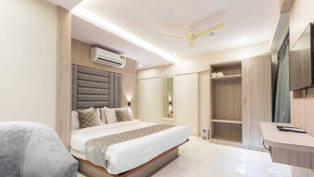 Une chambre moderne avec un grand lit, un bureau et une armoire.