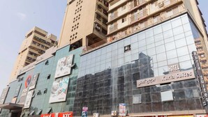 Un hôtel doté d’une façade moderne en verre, de plusieurs étages et de balcons.