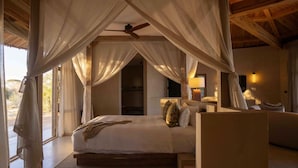 Une chambre à coucher avec un lit à baldaquin, une table de chevet et une petite table de nuit.