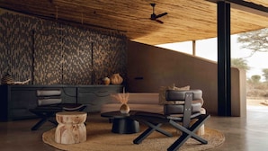 Un salon moderne avec un canapé, une table basse et des fauteuils.