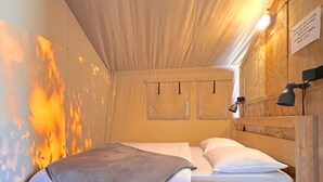 Una camera accogliente con un letto, una testiera in legno e una lampada a parete.