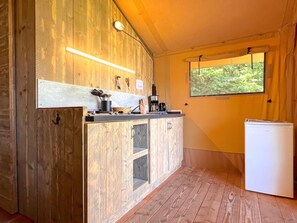 Eine kleine Küche mit Holdekor, einer Arbeitsplatte und einem Kühlschrank.