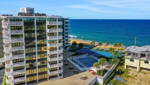 Un hotel di grandi dimensioni con numerosi balconi, una piscina e vista sulla spiaggia.