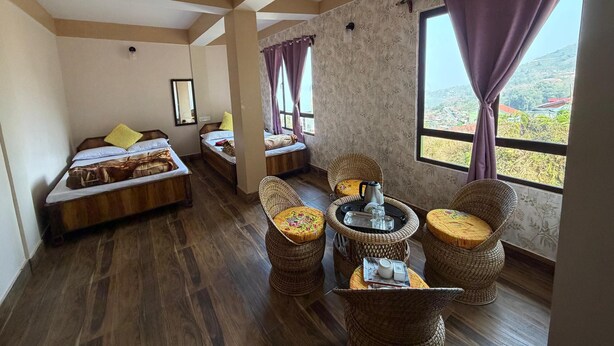 A room with two beds, a dining area with wicker furniture, and large windows with curtains. - K2view Retreat (Darjeeling)