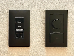 Two black electrical boxes, one with a USB PD port and the other with a circular dial, mounted on a textured wall. - hatago STAY Shinmachi (Nakatsugawa)