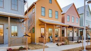 A row of modern, multi-story houses with a covered porch and a small garden area. - Designer Wheeler Retreat: Walk to Dining! (Oklahoma City)