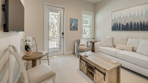 A living room with a sofa, coffee table, and chairs. There is a door leading to an outdoor area, and a painting on the wall. - Walk to Springs, 700 Ft to Dtwn! Crystal River Gem (Crystal River)
