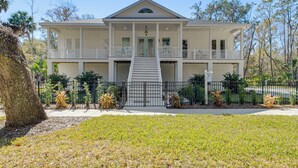 A two-story house with a central staircase, a balcony on the upper floor, and a fenced front yard. - Walk to Springs, 700 Ft to Dtwn! Crystal River Gem (Crystal River)