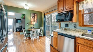 A kitchen with wooden cabinets, a stainless steel dishwasher, and a granite countertop.