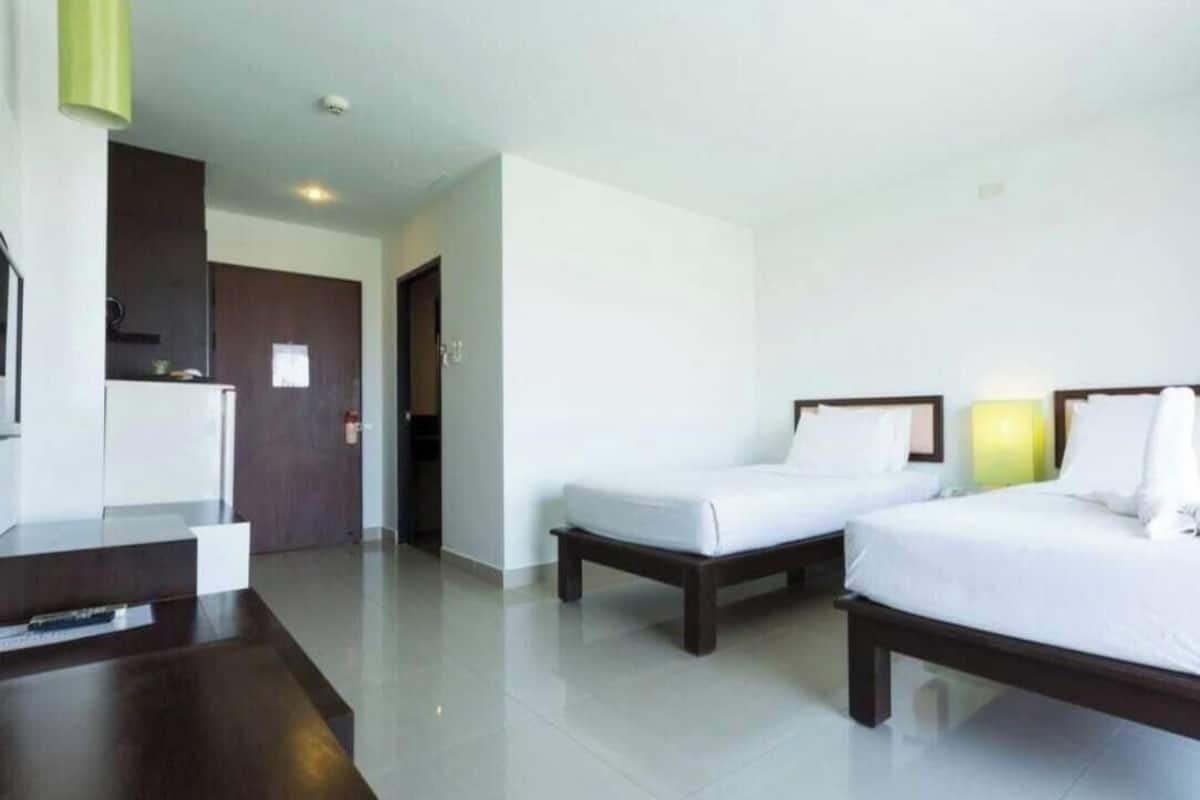 A hotel room with a bed, a desk, and a chair.