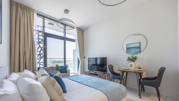 Une chambre d’hôtel moderne dotée d’un grand lit, d’un bureau avec une chaise, d’une télévision et offrant une vue sur la ville.