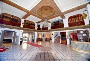 A spacious lobby with a high ceiling, intricate ceiling design, and a chandelier. - Hotel Nouzha (Fès)