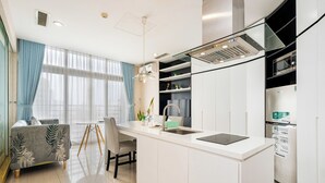 Eine moderne Küche mit einer weißen Kochinsel, einem eingebauten Backofen und einem Kühlschrank.