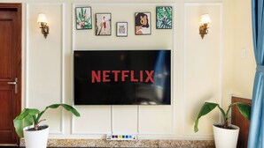 Ein flachbildfernseher an der Wand, mit dem Schriftzug 'NETFLIX' in Rot.