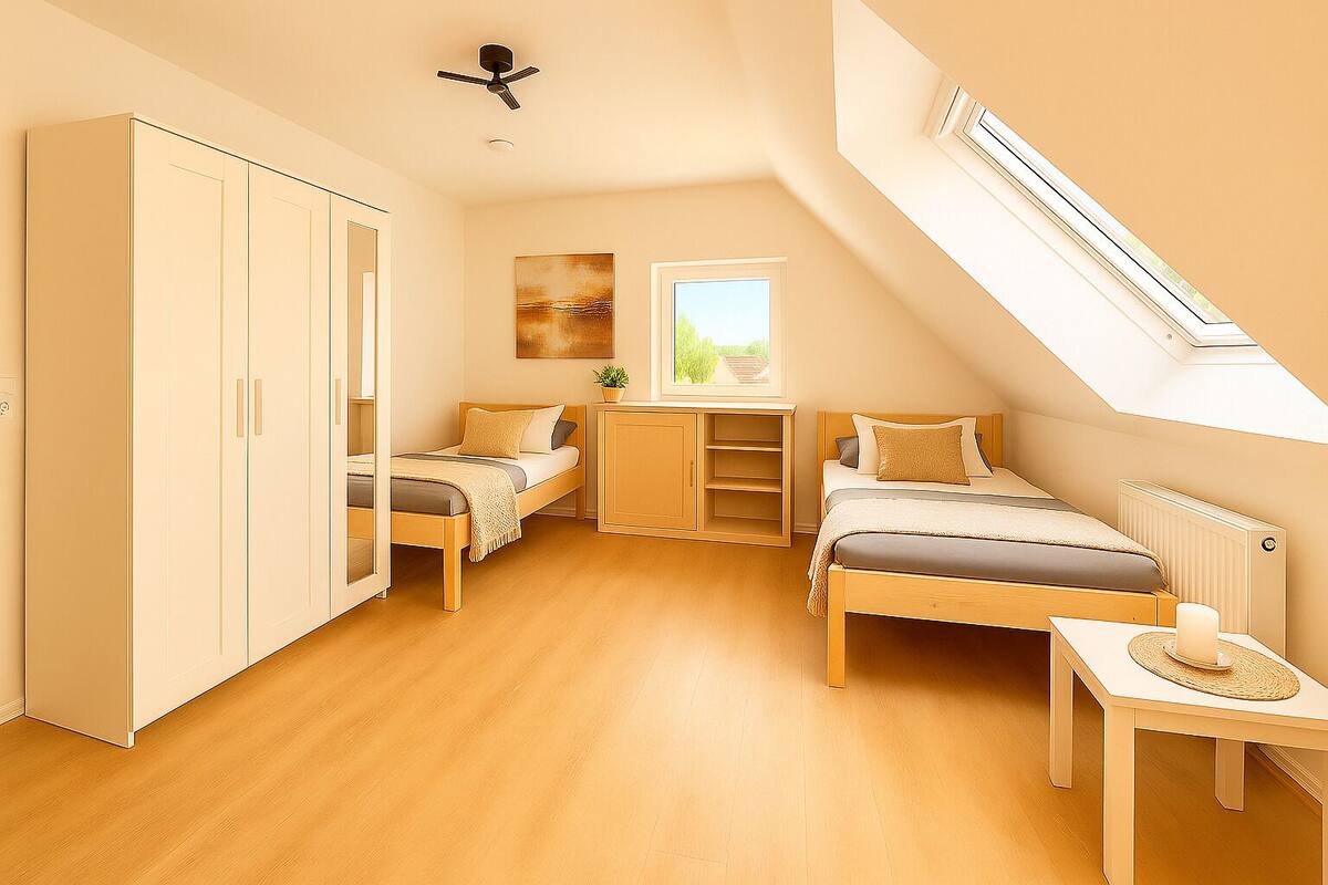 Une chambre avec deux lits, une armoire, un bureau et une fenêtre de toit.