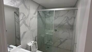 Chuveiro, toalhas de banho, sabonete, papel higiênico