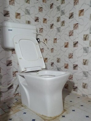 Chuveiro, chinelos, sabonete, papel higiênico