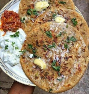 Une assiette avec des galettes, une cuillerée de yaourt et une sauce rouge.