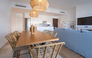 Eine moderne Küche mit weißen Schränken, einem Edelstahl-Kühlschrank und einer eingebauten Mikrowelle.