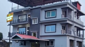 Un hôtel à plusieurs étages, doté de balcons et d’un toit rouge.