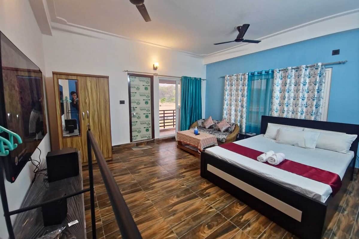 A bedroom with a bed, a desk, a mirror, and a ceiling fan.