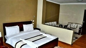 Une chambre d’hôtel avec un grand lit, un canapé et une petite table.