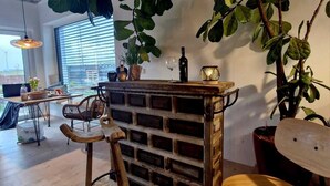 A rustic interior with a wooden bar, a large potted plant, and a dining area with a round table and chairs. - Stylish time-out near Nuremberg/Herzogenaurach (Hagenbüchach)