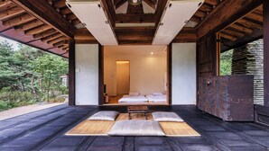 A traditional Japanese-style room with tatami flooring, a low wooden ceiling, and a view of a garden. - L'art de la vie Art & Resorts (Icheon)