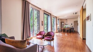 A spacious living area with a sofa, chairs, a dining table, and a kitchen in the background. - L'art de la vie Art & Resorts (Icheon)