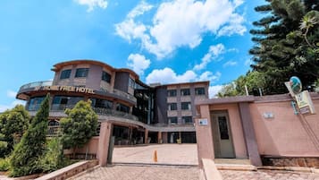 Un hôtel à plusieurs étages, doté d’une façade incurvée, d’un balcon et d’une enseigne indiquant « HOME FREE HOTEL ».