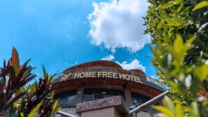 Um hotel com fachada curva, varanda e uma placa com a inscrição 'HOME FREE HOTEL'.