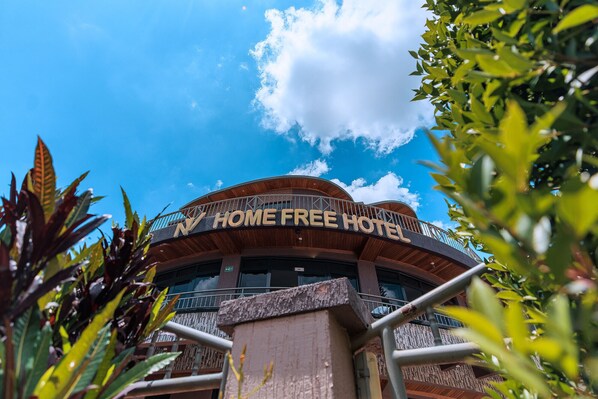 A hotel with a curved facade, a balcony, and a sign reading "HOME FREE HOTEL". - Homefree Hotel by signature (Kigali)