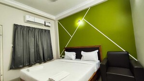 A hotel room with a bed, a chair, a ceiling fan, and a wall with geometric lighting. - Hotel Minati Palace (Puri)