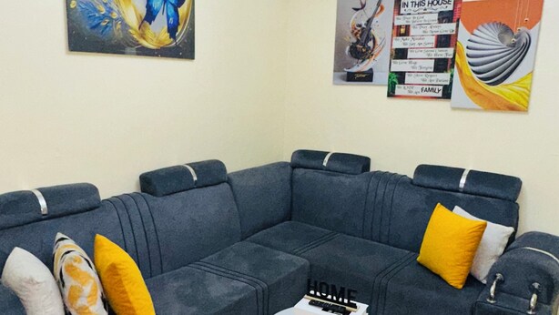 Ein modernes Wohnzimmer mit einem Ecksofa, einem runden Couchtisch und einer Kronleuchter.