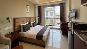 A hotel room with a bed, a desk, a chair, a TV, and a balcony with a view. - Townhouse Dharuhera Bus Terminal (Rewari)