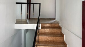 Een trap met een glazen balustrade en een rode deur aan de bovenkant.
