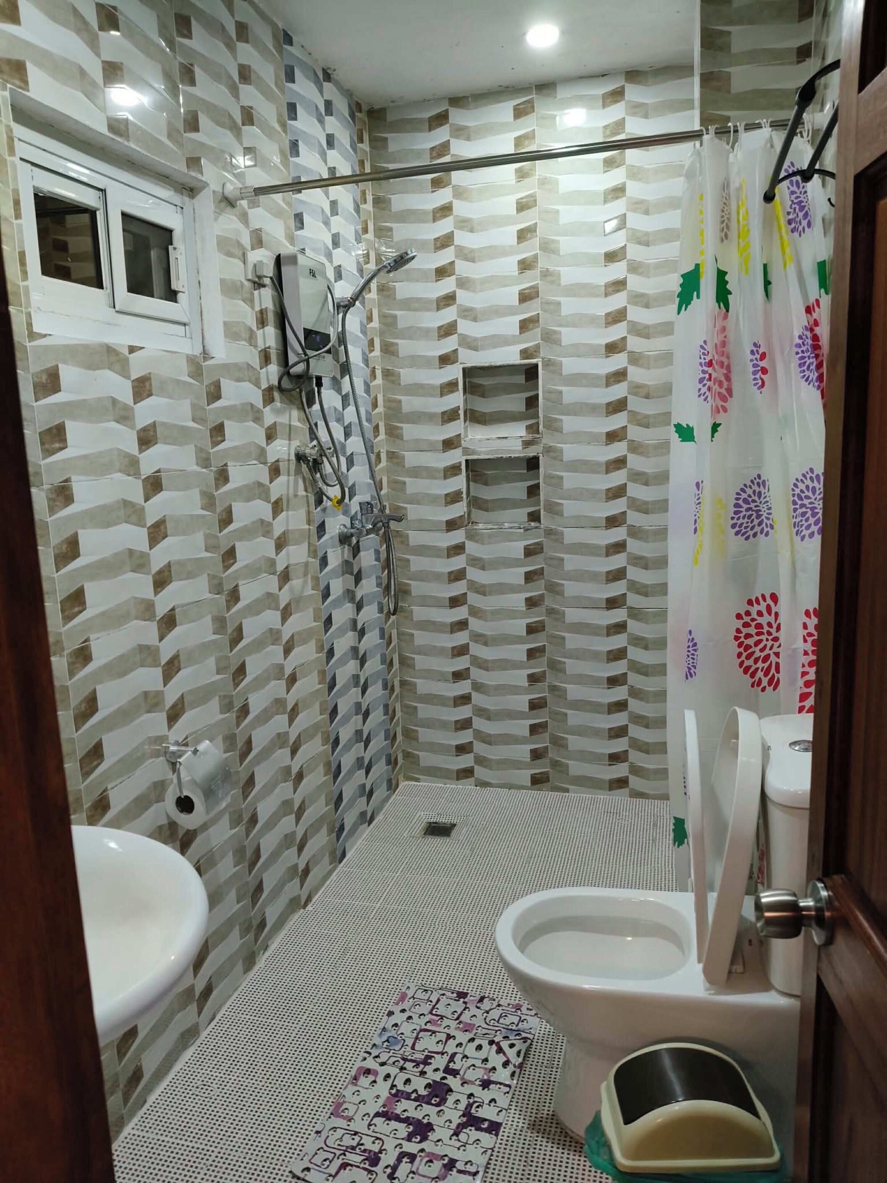 Un baño con ducha, inodoro y lavabo.
