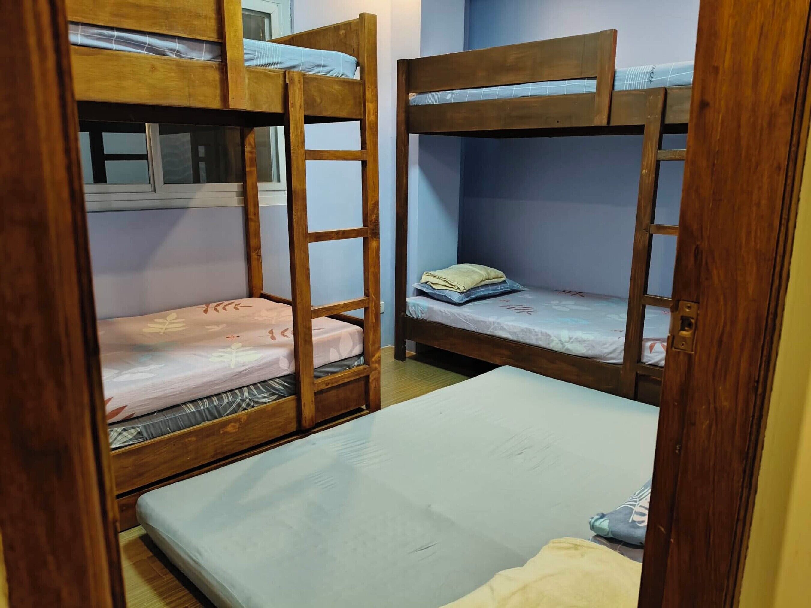 A room with two bunk beds and a single bed.