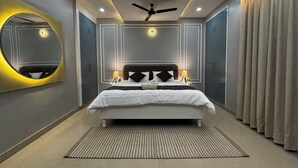 Un dormitorio moderno con una cama grande, ventilador de techo, luces empotradas y un espejo.
