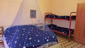 Een stapelbed met een sprei met sterenprint en een klamboe.