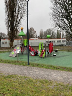 Un parque infantil con diversos juegos, incluyendo toboganes y columpios.
