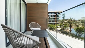 A balcony with a view of a modern building and a body of water. - Sunshine by Villacarte (Choeng Thale)